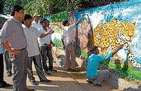 CHECK IT OUT! Deputy Commissioner Harsh Gupta and Mayor Sandesh Swamy inspecting the paintings done by CAVA students on the walls of Sri Chamarajendra Zoological Gardens, in Mysore on Wednesday. DH photo