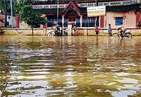 Drowned:  Rain water inundates a road in Shamanur near Davangere on Wednesday. DH Photo