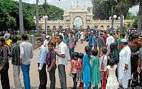 Tourists pouring : Visitors queueing up to the ticket counter outside the Mysore Palace as the number of tourists surge phenomenally in Mysore. (below) A filthy road behind KSRTC suburban bus stand, in Mysore. Dh Photos by Anurag Basavaraj