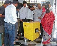 Locals take a look at the offering box at Guhe Kallamma temple in Hassan that was burgled recently. DH Photo