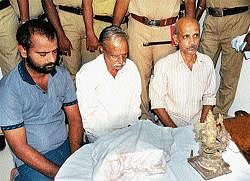 Heggaru Temple Priest Ramachandra Bhat (middle), Raghavendra Bhat (right) and Manjunath with antique idol and inscription. The seized packet contains duplicate idol.