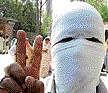 A masked youth flashes a V-sign during a protest on the outskirts of Srinagar on Wednesday. AFP