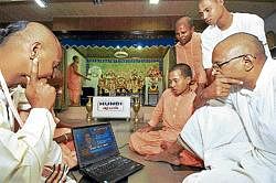 Glued to screen: Hindu priests watch the live updates of the Ayodhya verdict at the Jagannath temple. DH Photos by B H Shivakumar