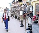 Toward better future: Security personnel look on as a schoolboy walks past on a street in Ayodhya on Thursday. AFP