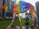 A tourist takes pictures of an art piece on a Dubai highway, March 14, 2004. Reuters