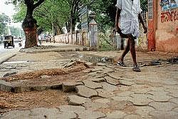 In mess: The kerb stones that have come up on a footpath in front of city Municipal Council in Mandya. DH Photo
