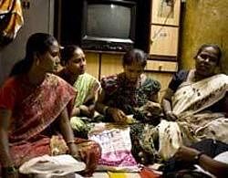 Not charity: Ramila Chawda, second from right, leads a group of female customers of Ujjivan, a microfinance firm from Bangalore that lends to the poor, counting money for the repayment of a loan at a branch of the firm in Mumbai. NYT