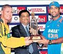 Battle for supremacy: Australian skipper Michael Clarke and Mahendra Singh Dhoni at the unveiling of the one-day trophy in Kochi on Friday. PTI