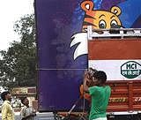 Workers load banners displaying the Commonwealth Games mascot Shera, a day after the closing of the Games, in New Delhi on Friday. PTI