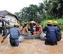 After the rains: Fire and Emergency personnel shift residents to safer places as rainwater cut off road link to their houses in Jeppinamogaru in Mangalore on Friday.  DH Photos