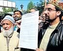 Chairman of All Parties Hurriyat Conference (APHC) Mirwaiz Umar Farooq holds a draft petition addressed to US President Barack Obama during a press conference at APHC headquarters in Srinagar on Sunday. AFP