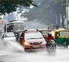 Vehicles pass through the water-logged J C Road in Bangalore on Sunday. DH photo