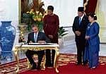 New beginning: President Barack Obama signs a welcome book as Michelle Obama, Indonesian President Susilo Bambang Yudhoyono and Indonesian first lady Kristiani Herawati Yudhoyono look on at Istana Merdeka, the Indonesian presidents palace in Jakarta. NYT