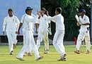 Flying High: Karnatakas Shreyas Gopal is congratulated by his team-mates after picking up the wicket of Bhargav Patel of Baroda at the RSI Grounds on Monday. DH Photo