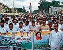 Rally: Congress activists taking out a protest rally in Hassan on Monday.   DH photo