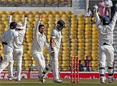 India's Pragyan Ojha (C) celebrates with teammates the dismissal of New Zealand's B McCullam during the fourth day of the final cricket Test match at Nagpur. PTI Photo