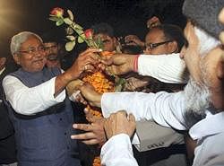 Bihar Chief Minister Nitish Kumar receives flowers from supporters during celebrations after his party JD(U) and the NDA won the state elections, in Patna on Wednesday. PTI
