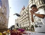 A man pays homage in front of portraits of police officers killed in the Mumbai terror attack outside the Taj Mahal Palace hotel, one of the sites of the attack, on the second anniversary of the attack in Mumbai, India on Friday. AP Photo