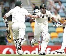 Australia's Mike Hussey, right, celebrates reaching his century as he runs past his teammate Brad Haddin, left, during the third day of their first Ashes cricket test against England in Brisbane, Australia, on  Saturday. AP
