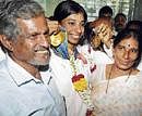 Ashwini with her parents at the Bajpe airport in Mangalore on Tuesday. DH photo