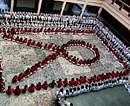 Surat: School students assemble to form AIDS symbol on the eve of World AIDS Day, in Surat on Wednesday. PTI Photo