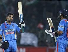 India's Gautam Gambhir raises his bat after scoring a century as teammate Virat Kohli, right, applauds, during the second one day international cricket match against New Zealand in Jaipur, India on Wednesday. AP Photo