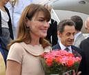 France's President Nicolas Sarkozy, right, and his wife Carla Bruni-Sarkozy, left, receive flowers as they arrive in Bangalore, Saturday, Dec. 4, 2010. Sarkozy arrived on a four-day visit to India, seeking to drum up business for French firms, with a deal expected on building nuclear plants to feed the Asian giant's burgeoning energy needs.(AP Photo/Philippe Wojaze, Pool)