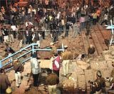 People look on as policemen and officials inspect the site of an explosion that rocked the holy town of Varanasi on Tuesday evening. PTI