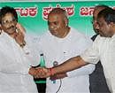 JD(S) Supremo H D Devegowda looks on as party's Karnataka unit chief H D Kumaraswamy (R) welcomes former Chief Minister S. Bangarappa into the party during a press conference in Bangalore on Wednesday. PTI Photo