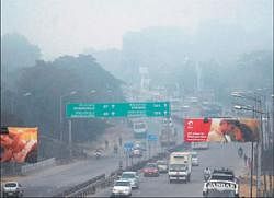 Motorists negotiate the mist-covered Hebbal Road in Bangalore on Friday. dh photos