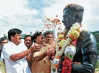 Mayor Sandesh Swamy, Medical Education and District In-charge Minister S A Ramadas offering floral tributes to the bust of Kuvempu at Vishwamanava Park. dh photo