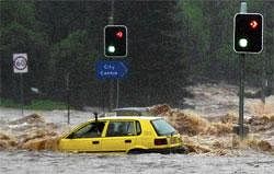 Seeking help: A passenger in a car waves for assistance as a flash flood sweeps across an intersection in Toowoomba, 105 km west of Brisbane, on Monday. Reuters