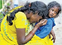 A woman grieves as she holds her daughter after identifying the body of her husband who died in the Sabarimala stampede, at a mortuary in Kochi on Sunday. AP