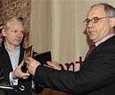 WikiLeaks founder Julian Assange and former Swiss banker Rudolf Elmer display two CDs containing details of money stashed in Swiss banks, in London on Monday. AP
