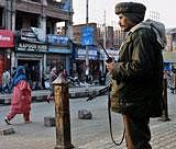 A CRPF jawan stands guard in a street in Srinagar on Monday. Security has been tightened in Srinagar in the view of Bharatiya Janata Yuva Morcha's Rashtriya Ekta Yatra enters the state of Jammu and Kashmir to hoist the tricolour at Lal Chowk on Republic Day. PTI