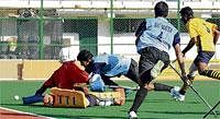 On Target SAI's Pradhan Somanna (centre) scores past ASC goalkeeper R Lakra during their Super Division League  hockey championship match on Tuesday. DH Photo