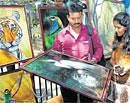 Varied strokes: Visitors appreciate an art work at the Chitra Santhe on Sunday. DH Photo