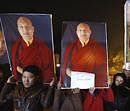 Tibetan exiles hold posters of Ugyen Thinley Dorje, the 17th Karmapa, at a candle light vigil in support of the Karmapa in New Delhi, on Saturday. AP