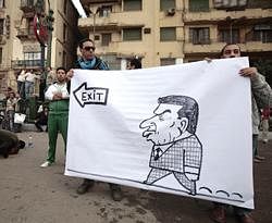 Protestors hold a banner next to people praying, left, during a demonstration in Cairo, Sunday Jan. 30, 2011. AP