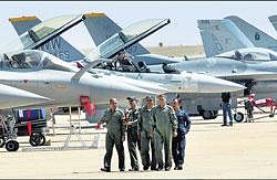 Indian Air Force personnel walk near parked aircraft after rehearsal on the eve of Aero India 2011 at Yelahanka Air Base in Bangalore on Tuesday. PTI