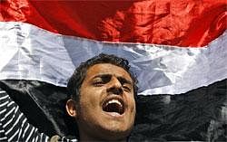 A Yemeni demonstrator shouts slogans while raising his national flag during an anti-government protest in Sanaa, Yemen. AP Photo