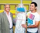 One for the album : Deccan Herald Editor KN Tilak Kumar hands over a bat containing a scroll of signatures from fans across the City wishing the Indian team good luck for the World Cup to skipper Mahendra Singh Dhoni in Bangalore on Saturday. DH Photo
