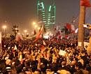 Bahraini anti-government protesters wave flags in a demonstration at the Pearl roundabout in Manama, Bahrain . AP