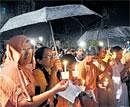 Seeking fresh probe: Braving a downpour, Christians participate in a candle-light rally against the Somasekara Commission report on church attacks, in Bangalore on Monday. DH Photo