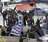 Under siege: Soldiers and other protesters stand over an army van shouting slogans against Moammar Gadhafi during a demonstration, in Tobruk, Libya, on Wednesday. AP