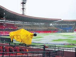 The playing area in the Chinnaswamy Stadium is flooded with rain water after a downpour on Friday in Bangalore. DH Photo/Srikanta Sharma R