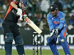 England's captain Andrew Strauss, left, bats as India captain Mahendra Singh Dhoni looks on during the Group B Cricket World Cup match between India and England in Bangalore on Sunday. AP