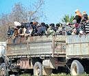 Asian workers sit on a truck in the Libyan eastern city of Benghazi as they flee the country on Monday. AFP