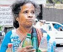Scare-city: A woman carries bottles filled with water at Corporation Colony in Jayanagar on Monday. DH photos/S K Dinesh
