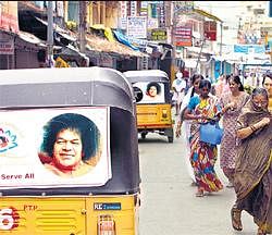 Omnipresent: Photographs of Sathya Sai Baba are displayed on auto rickshaws in Puttaparthi on Thursday. AP